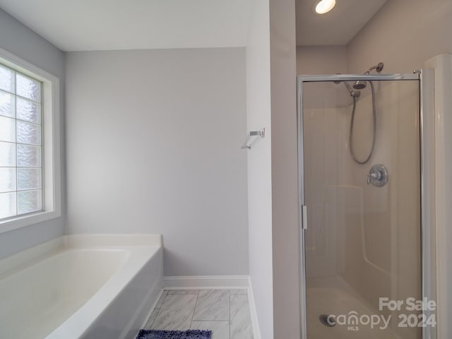 bathroom featuring shower with separate bathtub and plenty of natural light