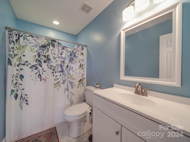 bathroom with tile patterned flooring, vanity, and toilet