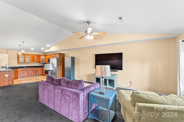 carpeted living room with ceiling fan, sink, and vaulted ceiling