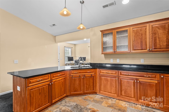 kitchen featuring kitchen peninsula, decorative light fixtures, and sink