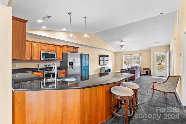 kitchen with ceiling fan, hanging light fixtures, stainless steel appliances, dark colored carpet, and lofted ceiling