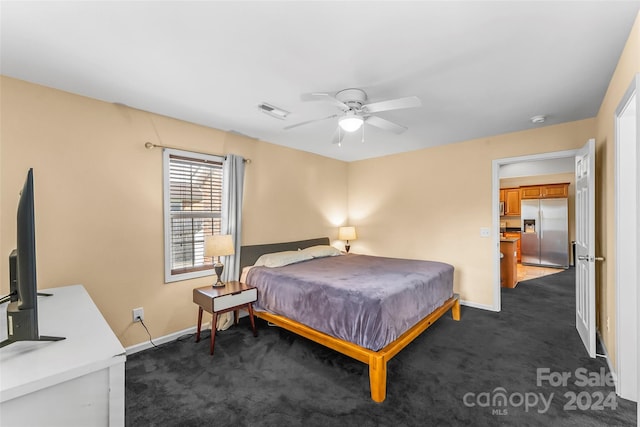 bedroom with dark colored carpet, ceiling fan, and stainless steel fridge with ice dispenser