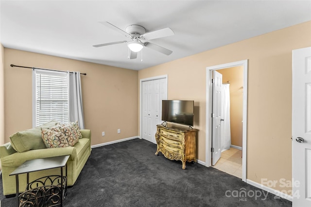 living area with ceiling fan and dark carpet