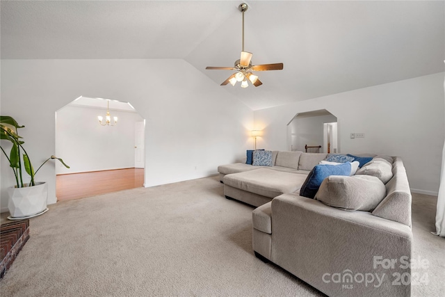 living room with carpet flooring, ceiling fan with notable chandelier, and lofted ceiling