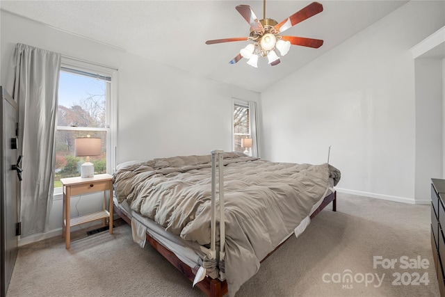 bedroom featuring multiple windows, light carpet, vaulted ceiling, and ceiling fan