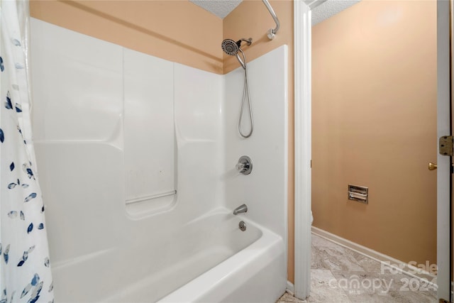 bathroom with a textured ceiling and shower / bathtub combination with curtain