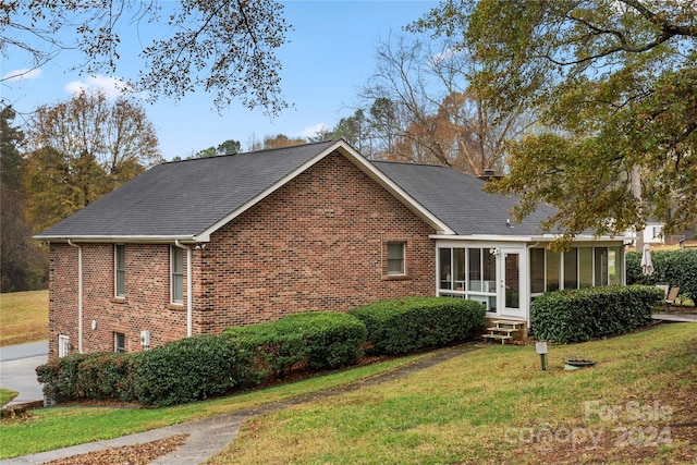 view of front of property featuring a front yard and a sunroom