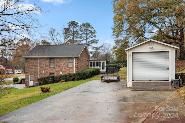 view of home's exterior with central AC unit, an outdoor structure, a garage, and a yard