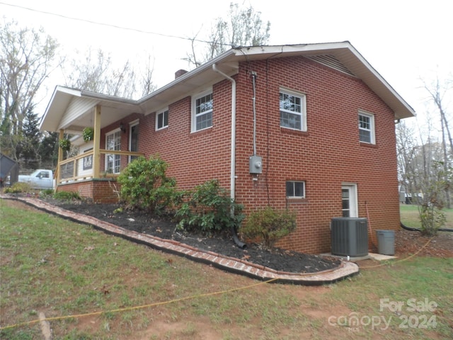 view of property exterior with a yard and central AC unit