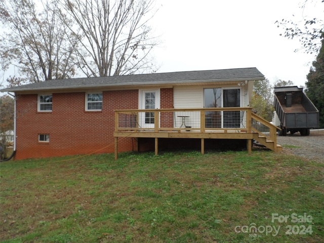 back of property with a lawn and a wooden deck