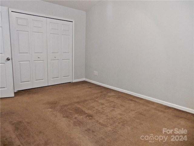 unfurnished bedroom featuring carpet and a closet