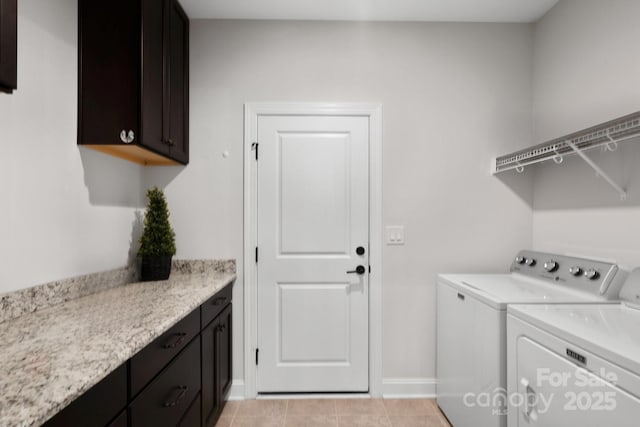 clothes washing area with cabinets, light tile patterned floors, and washing machine and dryer