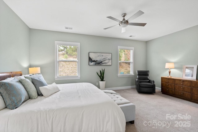 carpeted bedroom featuring multiple windows and ceiling fan