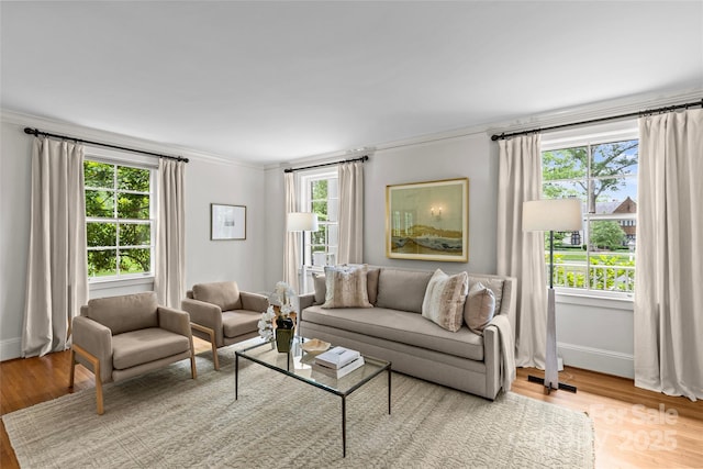 living room featuring healthy amount of natural light, crown molding, wood finished floors, and baseboards