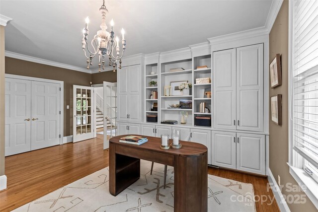 office with light wood-style flooring, a chandelier, ornamental molding, and baseboards