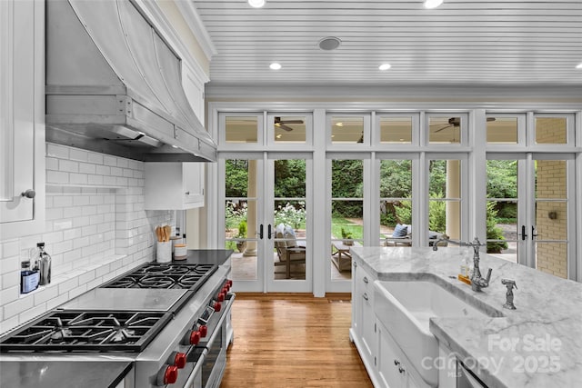 kitchen featuring french doors, extractor fan, double oven range, a sink, and plenty of natural light