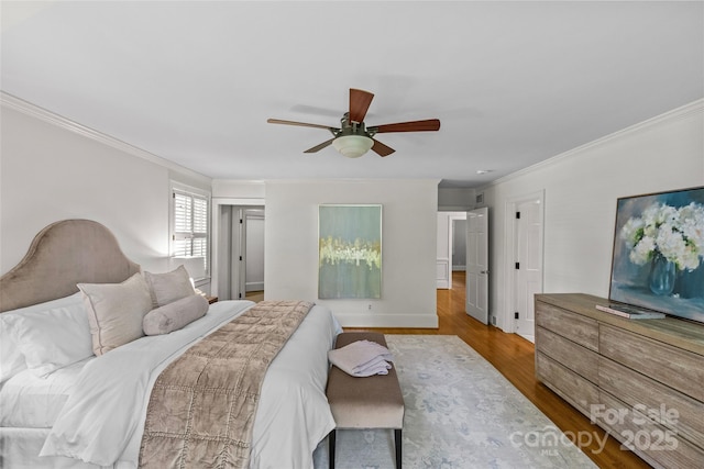 bedroom with crown molding, wood finished floors, ceiling fan, and baseboards