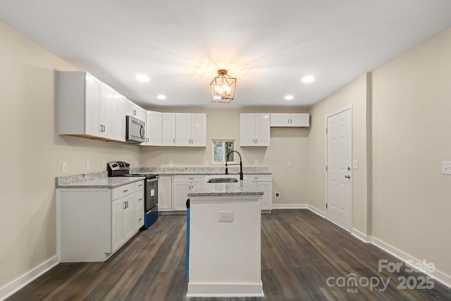 kitchen featuring white cabinetry, sink, light stone counters, and appliances with stainless steel finishes