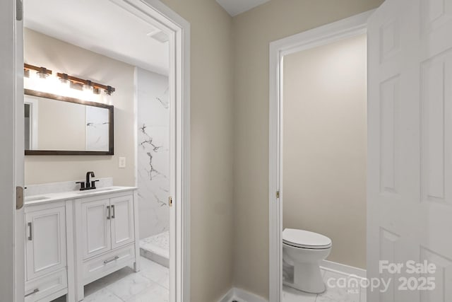 bathroom with a shower, vanity, and toilet