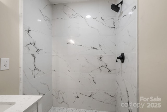 bathroom featuring vanity and tiled shower