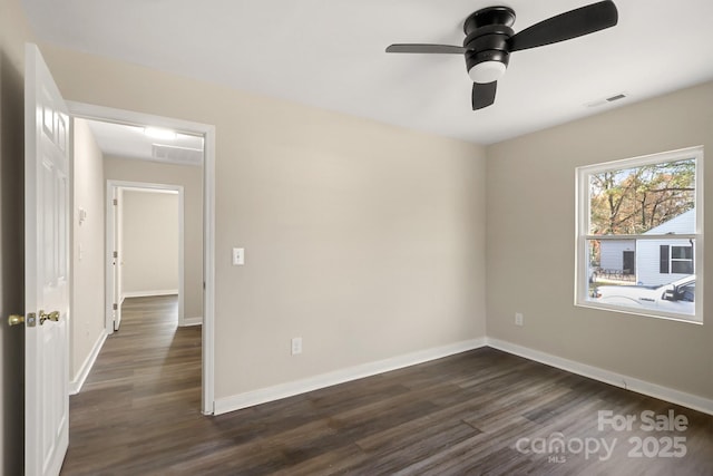 spare room featuring ceiling fan and dark wood-type flooring