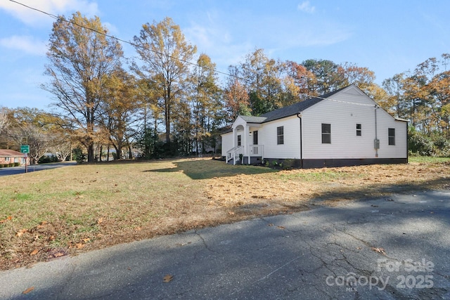 view of side of home with a yard