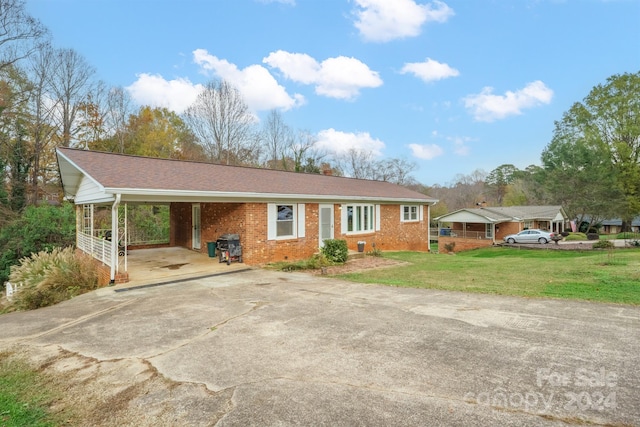 single story home featuring a front lawn and a carport