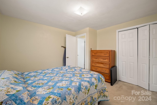 bedroom with light colored carpet and a closet