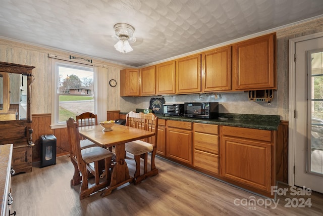 kitchen with wooden walls, light hardwood / wood-style flooring, and crown molding