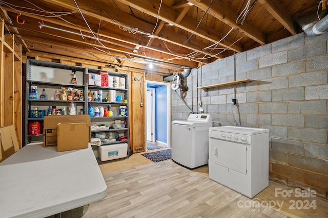 basement featuring light wood-type flooring and independent washer and dryer