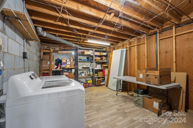 basement featuring washer and dryer and light hardwood / wood-style floors