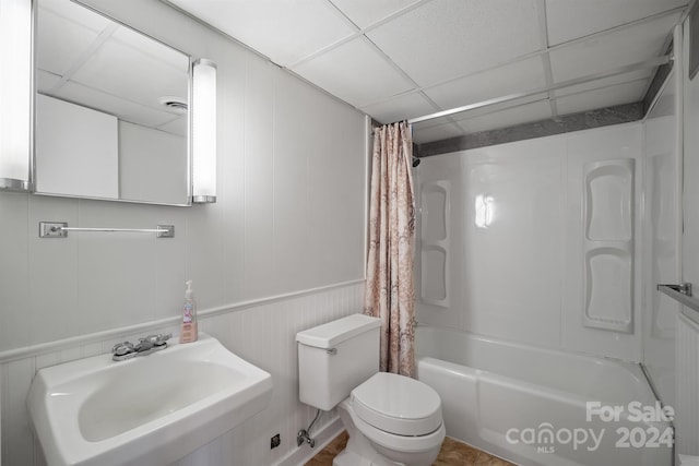 full bathroom with sink, tile patterned flooring, toilet, a paneled ceiling, and shower / tub combo with curtain