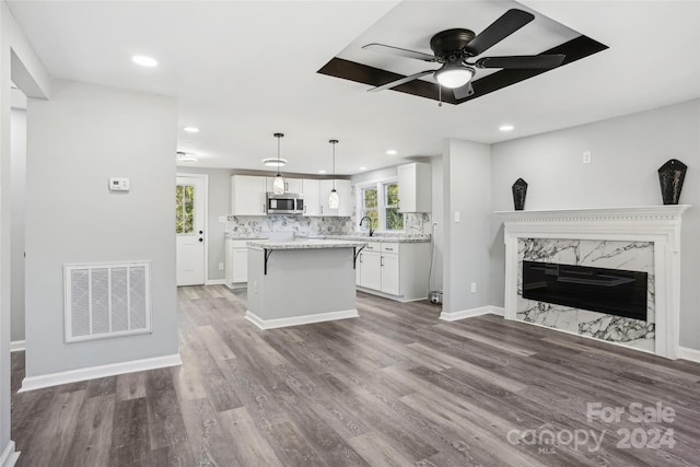 kitchen featuring white cabinets, pendant lighting, hardwood / wood-style flooring, and plenty of natural light