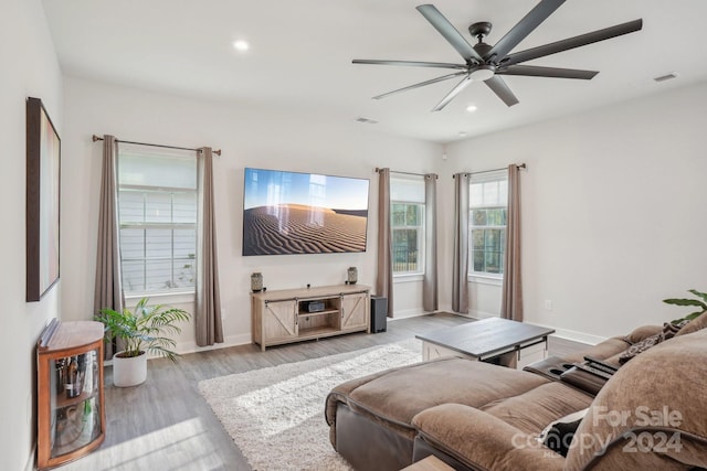 living room featuring light hardwood / wood-style flooring and ceiling fan