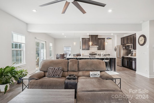 living room with ceiling fan and light wood-type flooring