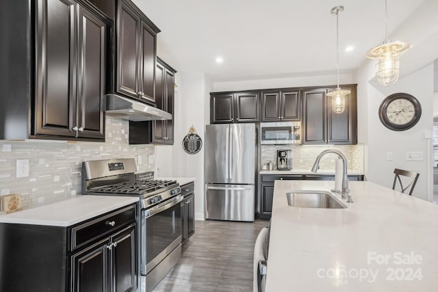 kitchen featuring backsplash, dark wood-type flooring, sink, hanging light fixtures, and stainless steel appliances