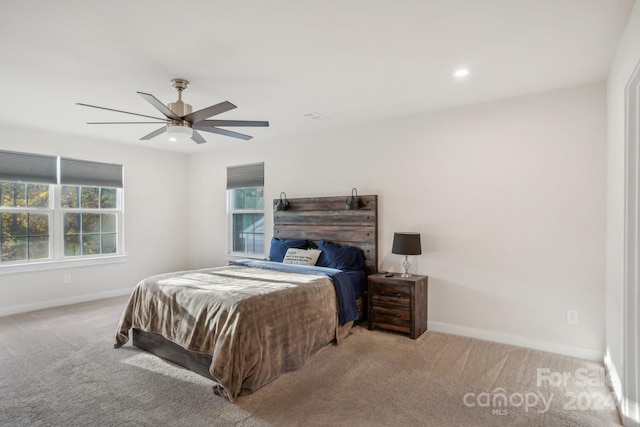 carpeted bedroom with multiple windows and ceiling fan