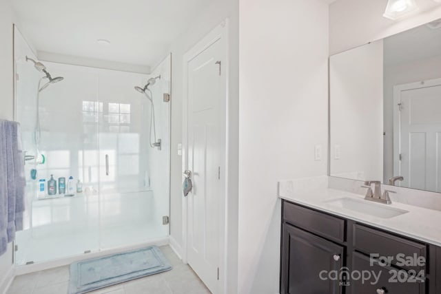 bathroom featuring tile patterned floors, vanity, and a shower with shower door