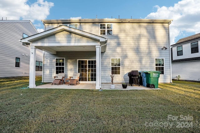 rear view of house with a lawn and a patio