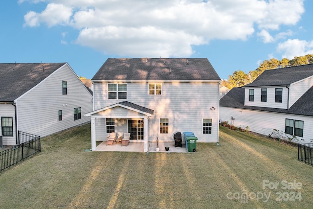 rear view of property featuring a lawn and a patio area