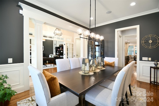 dining space featuring french doors, ornamental molding, dark wood-type flooring, and an inviting chandelier