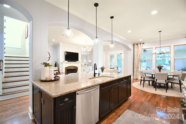 kitchen featuring stainless steel dishwasher, dark hardwood / wood-style flooring, light stone countertops, and hanging light fixtures