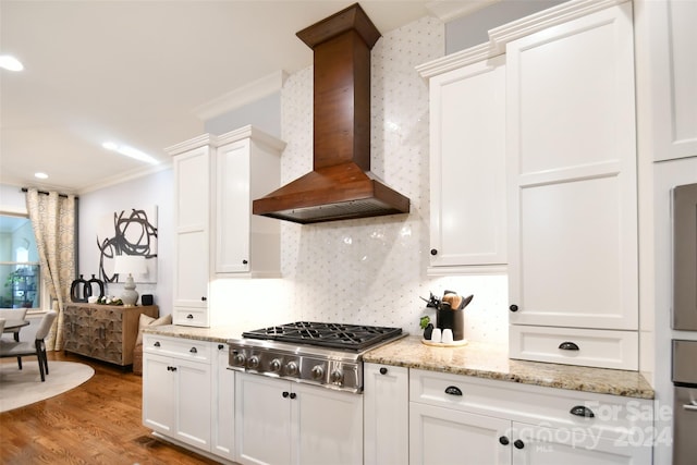 kitchen featuring premium range hood, ornamental molding, hardwood / wood-style floors, white cabinetry, and stainless steel gas stovetop