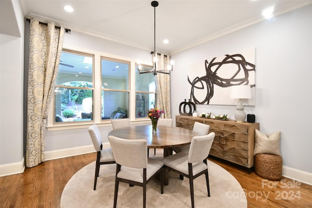 dining area featuring hardwood / wood-style flooring, crown molding, and a notable chandelier