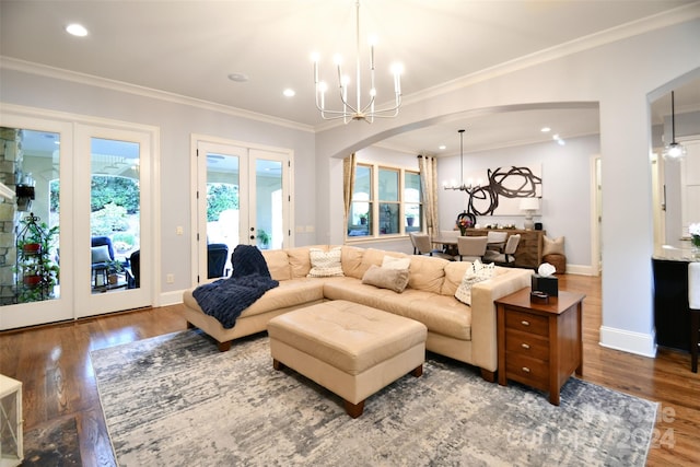 living room featuring french doors, hardwood / wood-style flooring, an inviting chandelier, and crown molding