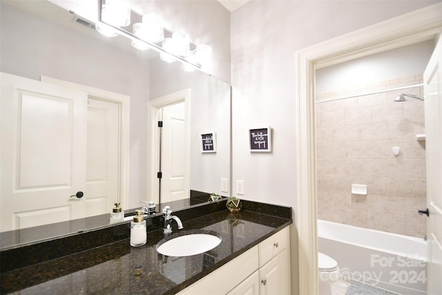 full bathroom featuring vanity, toilet, and tiled shower / bath