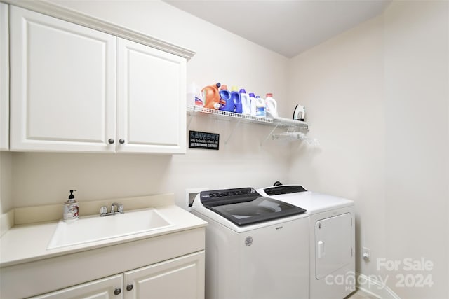 laundry area with washing machine and dryer, sink, and cabinets