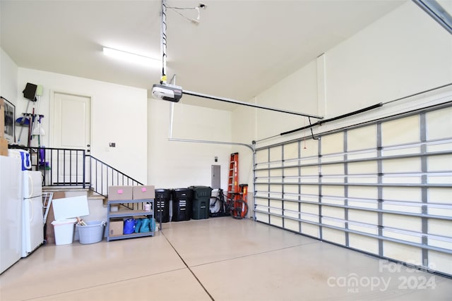 garage featuring white refrigerator and a garage door opener