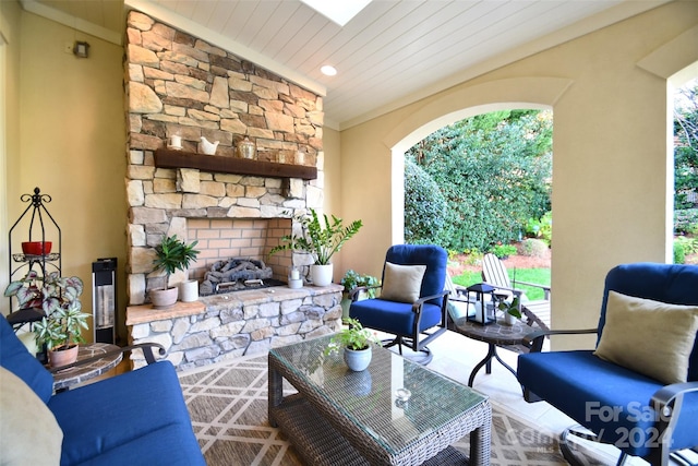 living room featuring an outdoor stone fireplace, plenty of natural light, and lofted ceiling