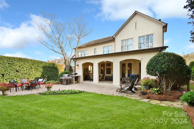 rear view of house featuring a yard and a patio area